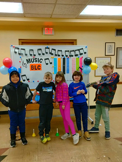 Five students posing in front of music decorations during our release day care on MPLS no school days. Full day care available for elementary students.